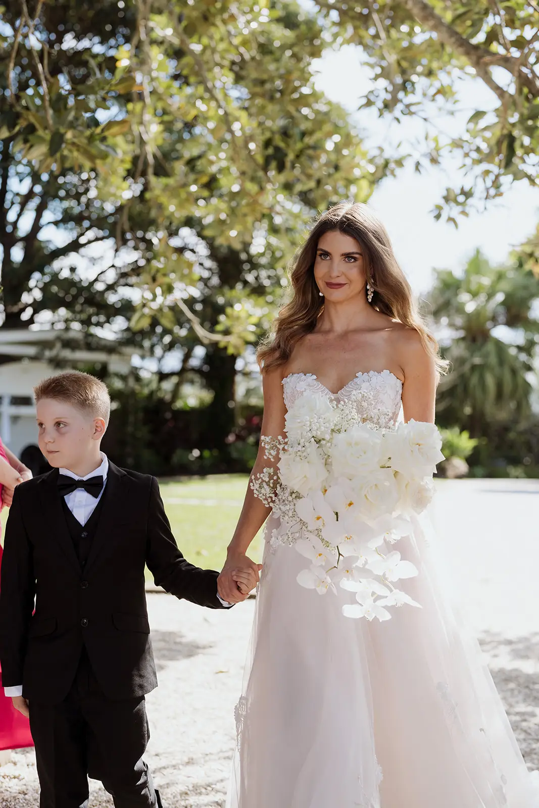 Letitia walking to the ceremony with a young page boy, Fig Tree Restaurant