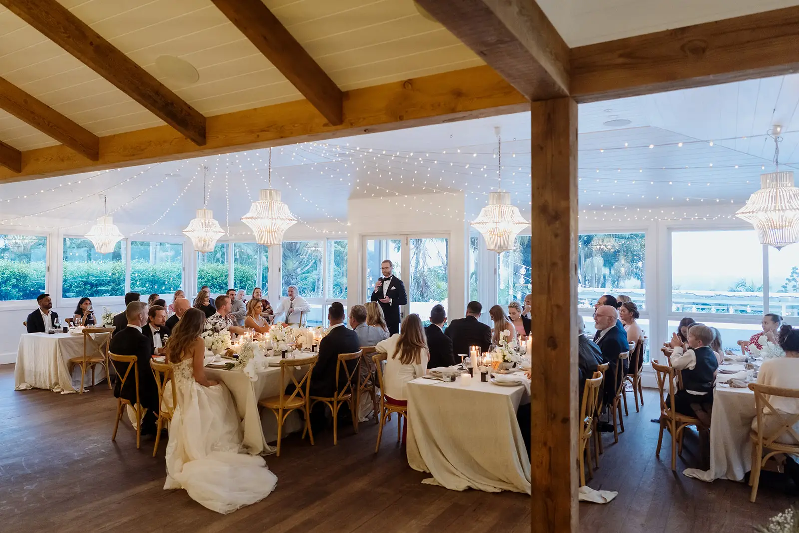 The restaurant in daylight — timber beams, chandeliers and round tables looking out to the view, Fig Tree Restaurant