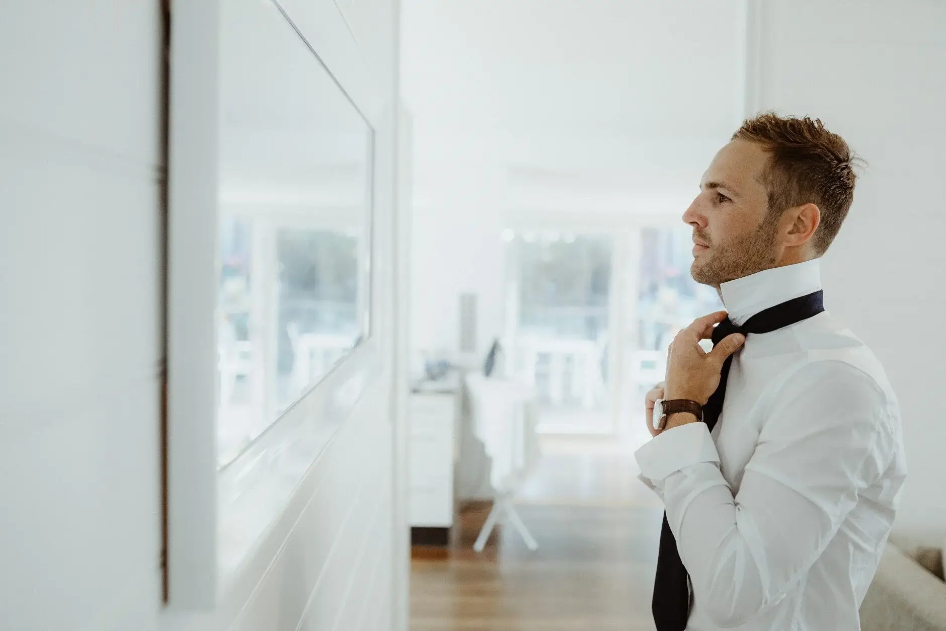 Nev doing up his bow tie by the window, Byron Bay