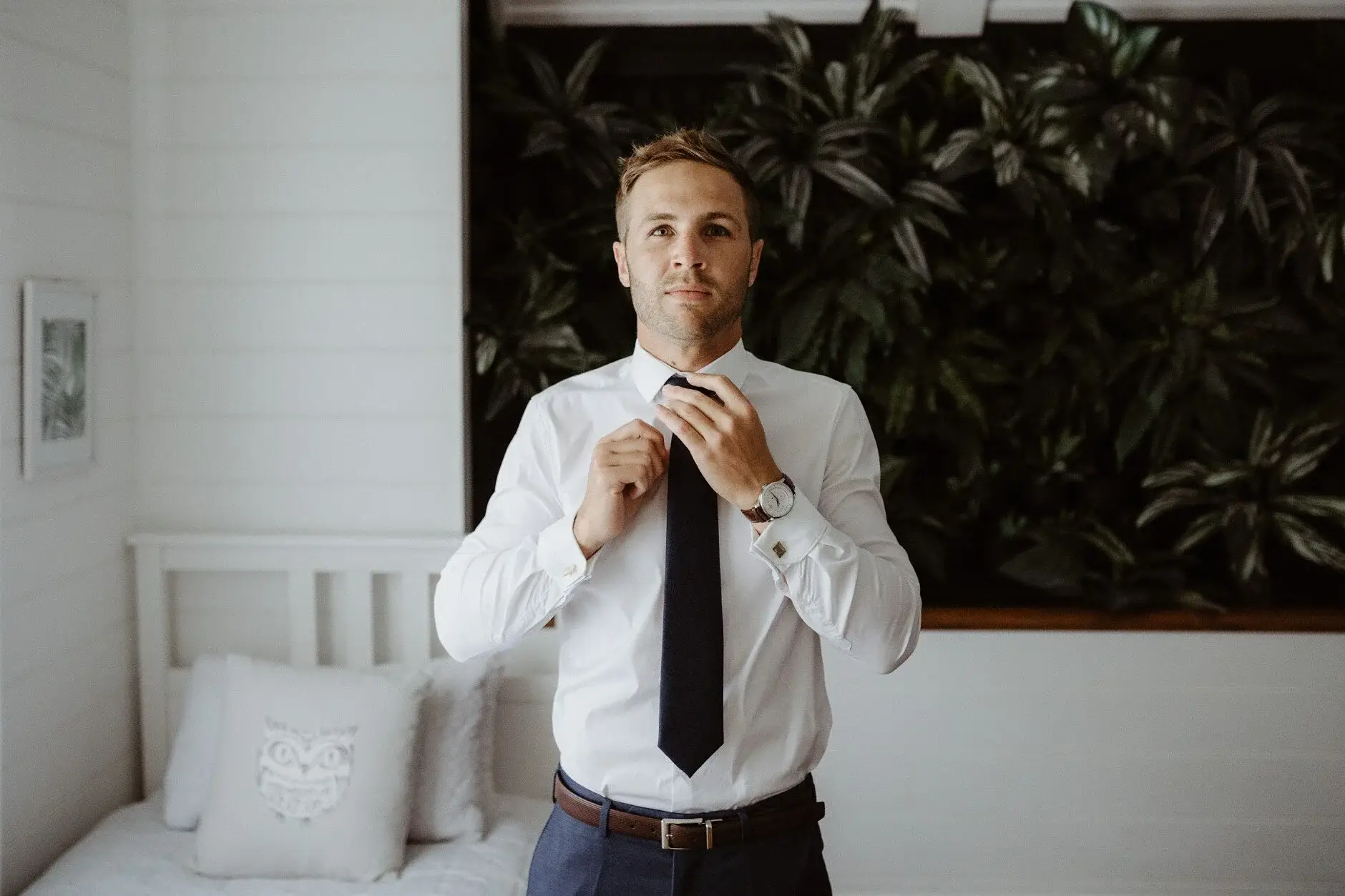 Nev straightening his tie against the greenery, Byron Bay