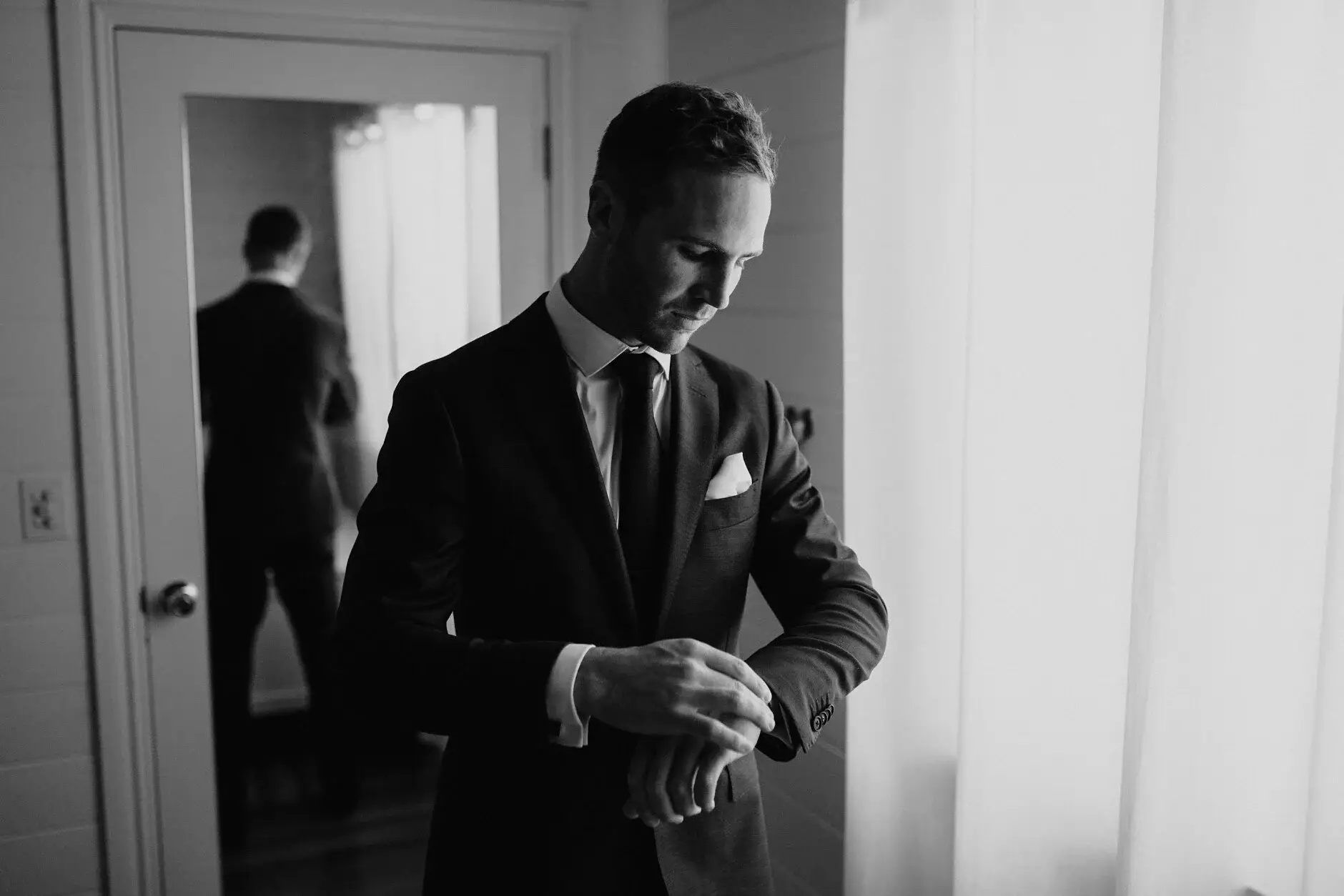 Nev checking his watch in the doorway, black and white, Byron Bay