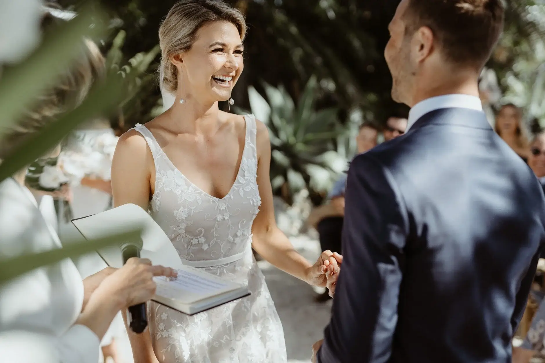 Em laughing during the ceremony as Nev holds her hands, Byron Bay