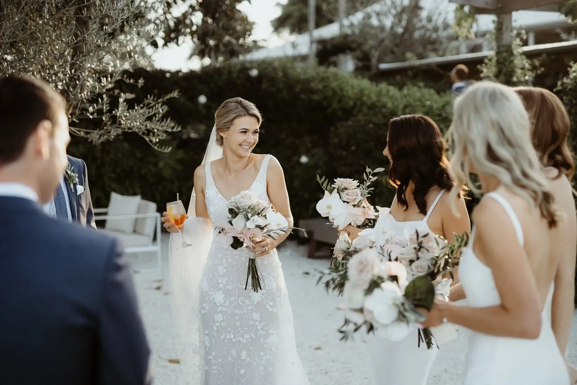 Em laughing with her bridesmaids, bouquets in hand, Byron Bay