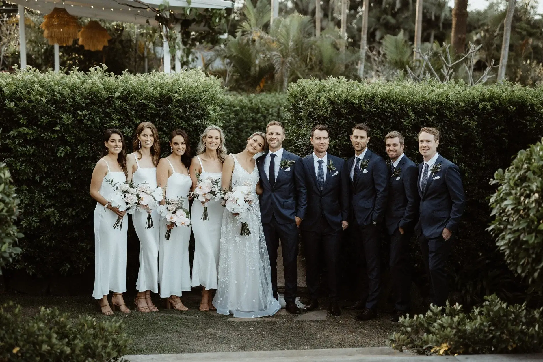 The whole bridal party along the hedge at the Fig Tree, Byron Bay