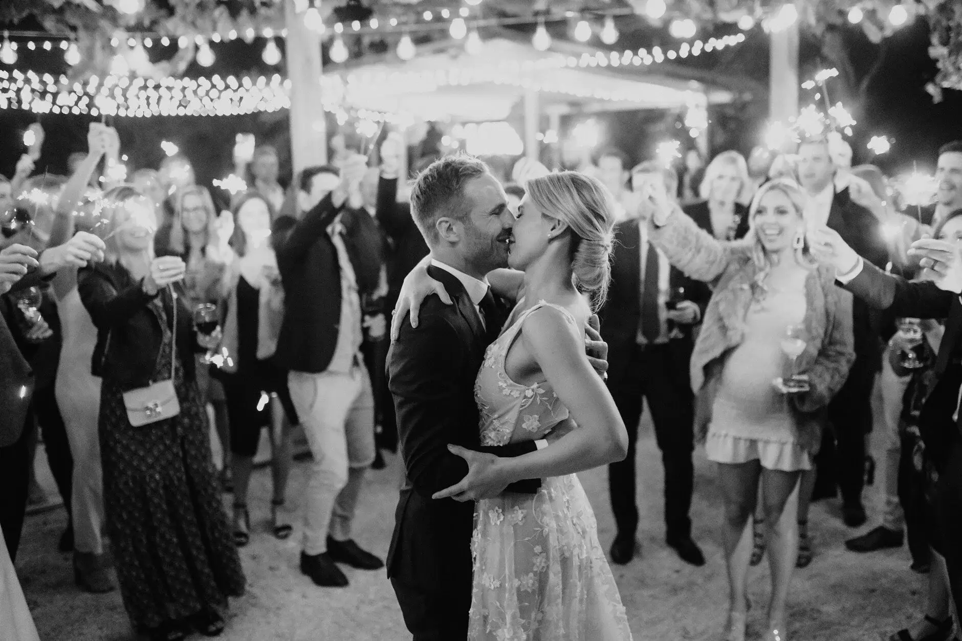 Em and Nev kissing on the dance floor under festoon lights, Byron Bay