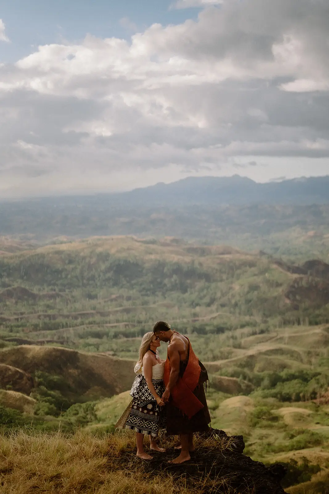 The couple sitting together on a rock above the valley, Fijian highlands