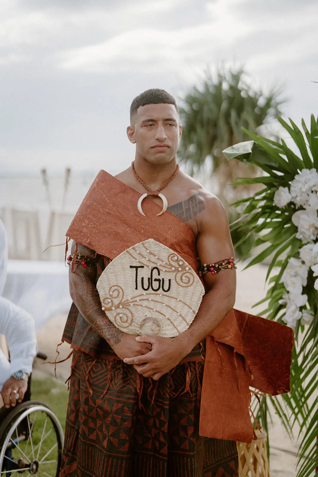 A groomsman holding a personalised woven fan, Nadi Bay