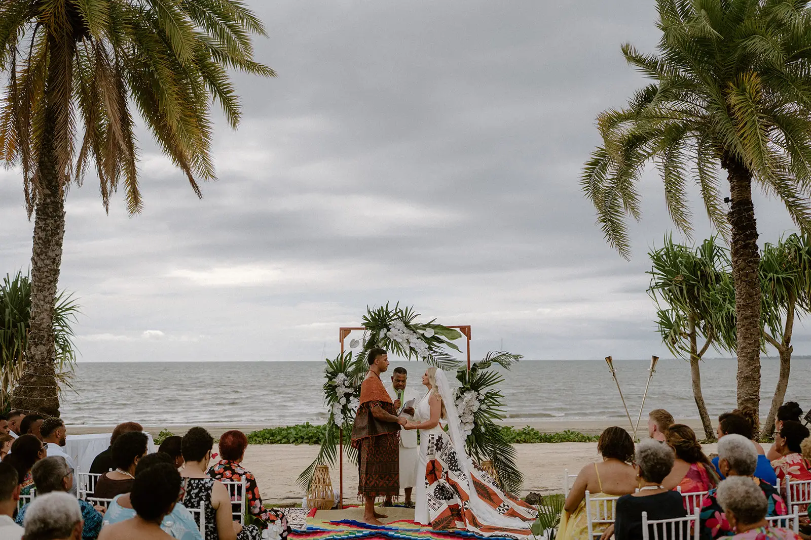 Ceremony beneath the floral arch beside the sea, Nadi Bay, Fiji