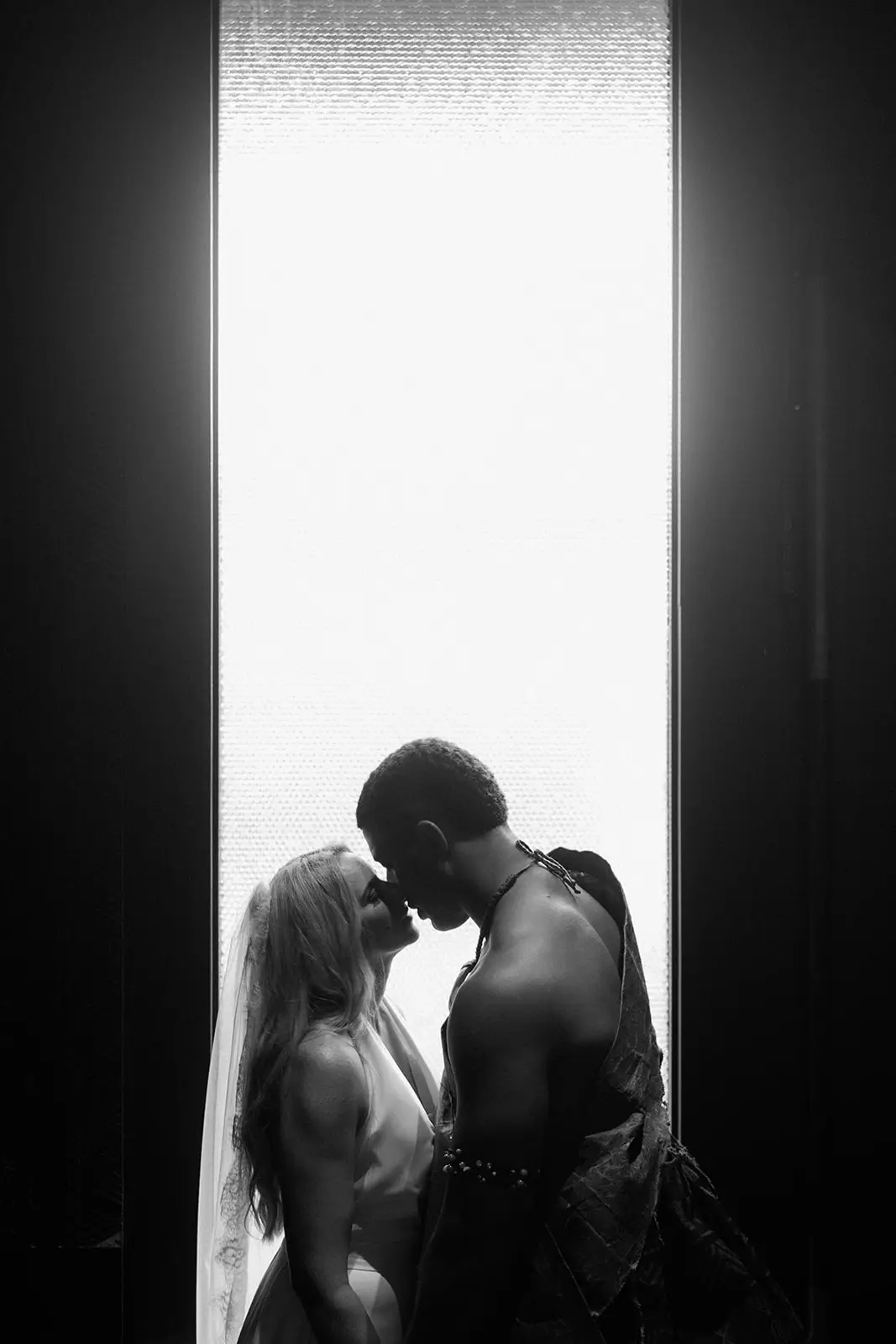 Brittany and Viliame kissing in a doorway, silhouetted, Nadi Bay