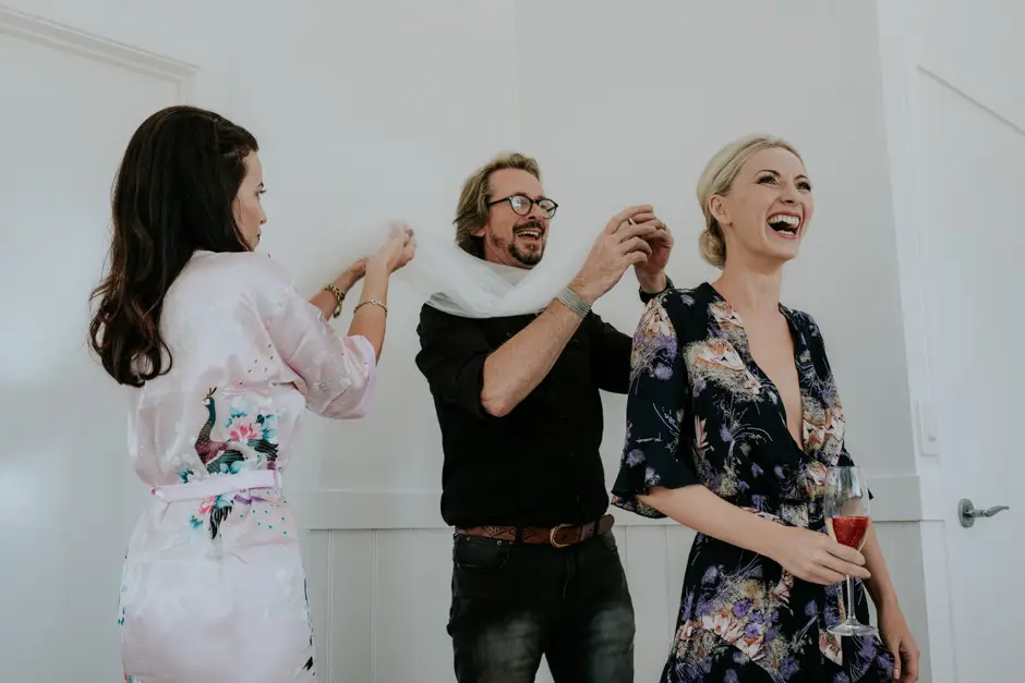 Bridesmaids and a friend laughing over a drink while getting ready, Goremans Road