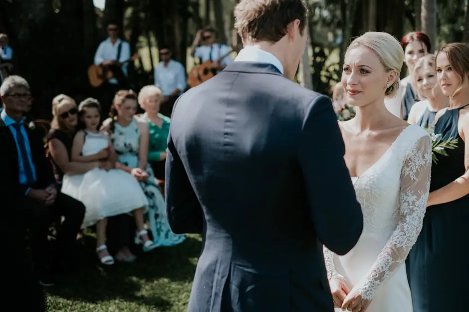 Jarrod and Jessica during the ceremony with guests seated behind them, Eureka