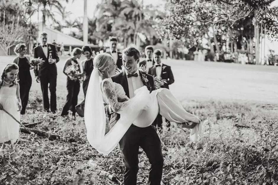 Jarrod carrying Jessica through the grass, her veil flying, Eureka