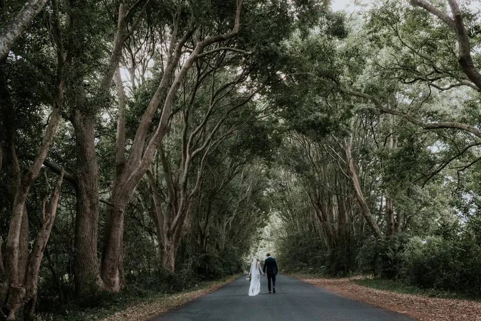 Jessica and Jarrod far down a road tunnelled by trees, Eureka