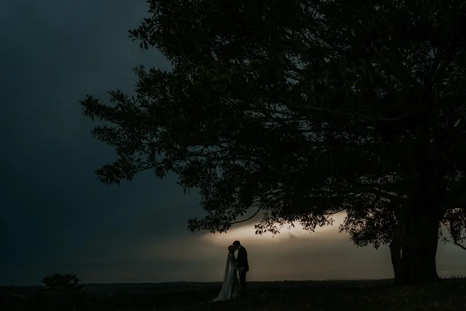 The couple silhouetted beneath the tree under a stormy sky, Eureka