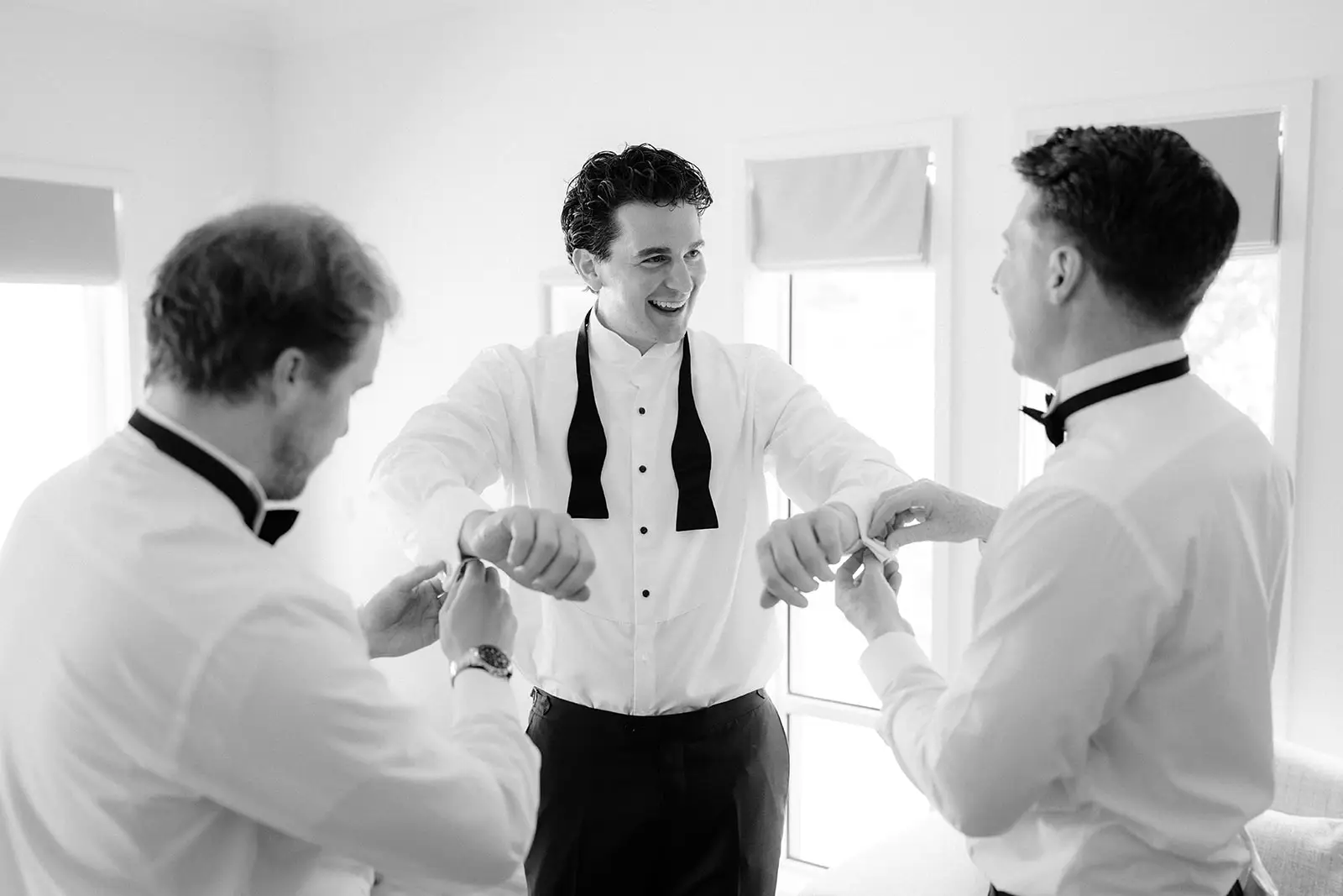 Groomsmen helping each other with their bow ties, Newrybar