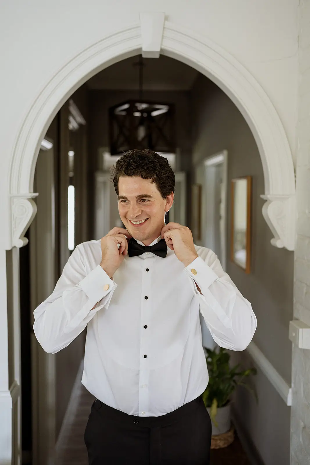 Tom adjusting his bow tie in the hallway, Byron Bay hinterland