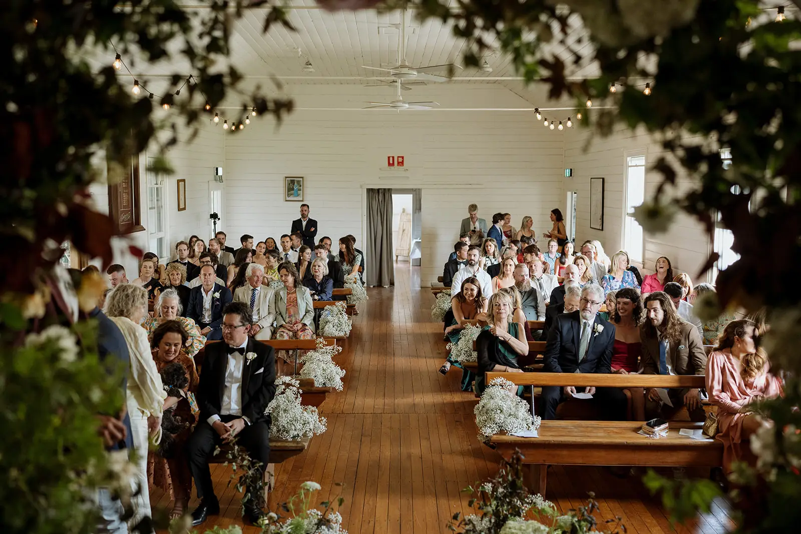 The ceremony aisle framed by hanging greenery, Newrybar hall