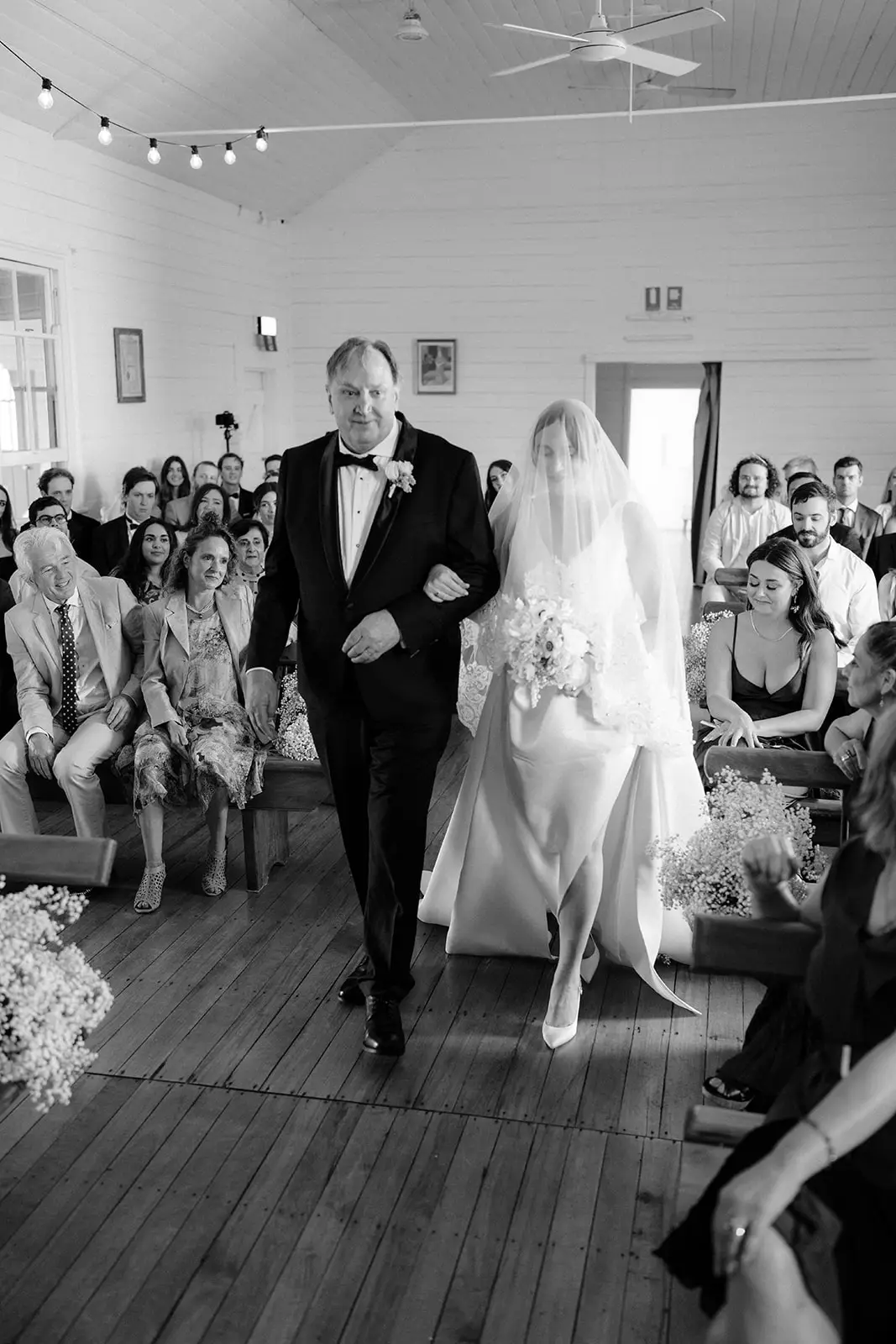 Nim and her father partway down the aisle, Newrybar