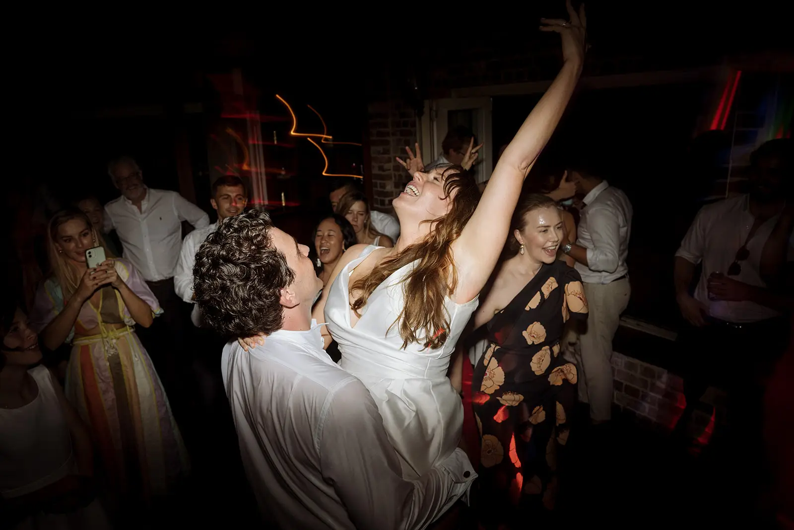 A guest with arms raised in the champagne spray, Harvest Newrybar