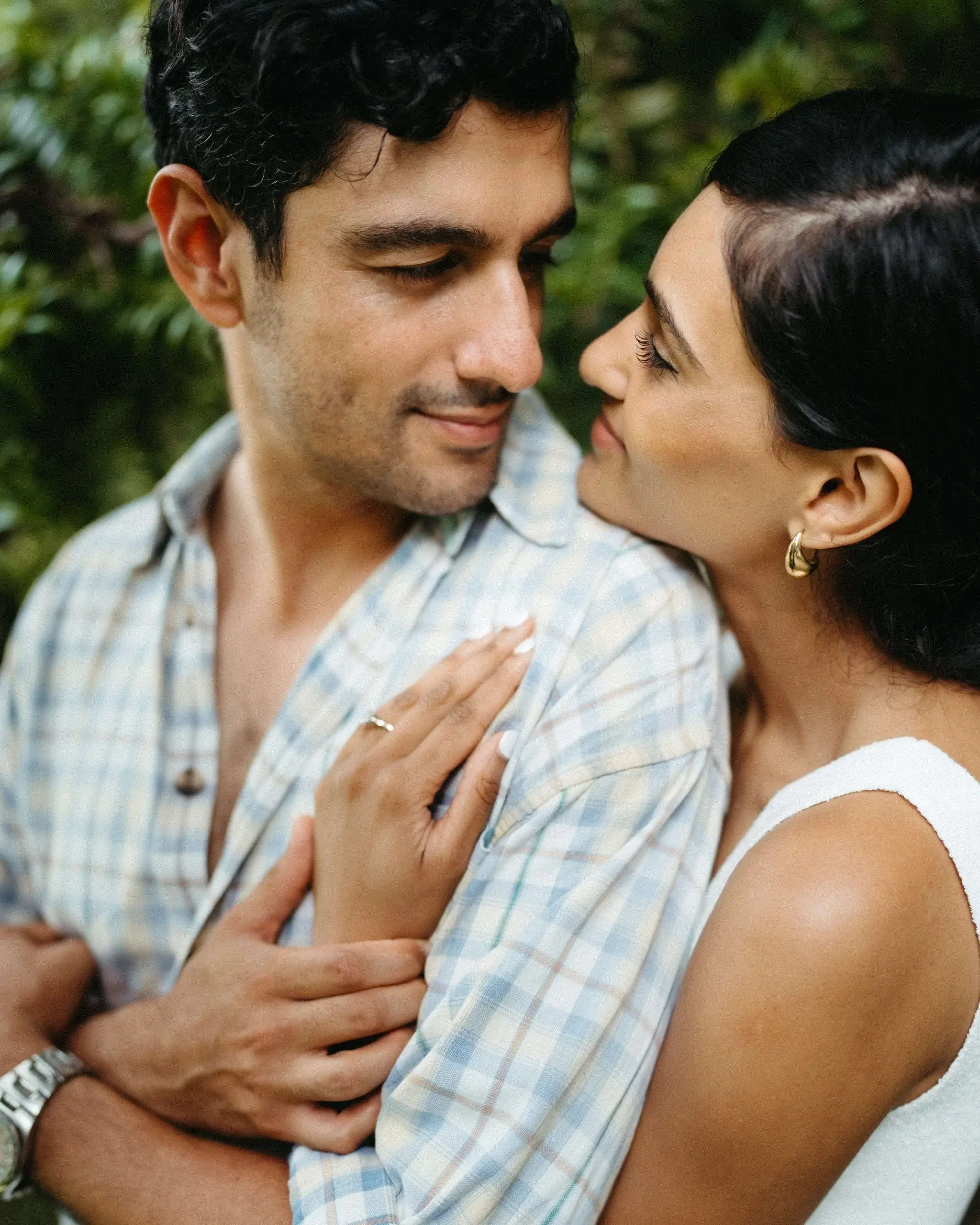 Close-up of a couple holding each other, hands crossed at the chest