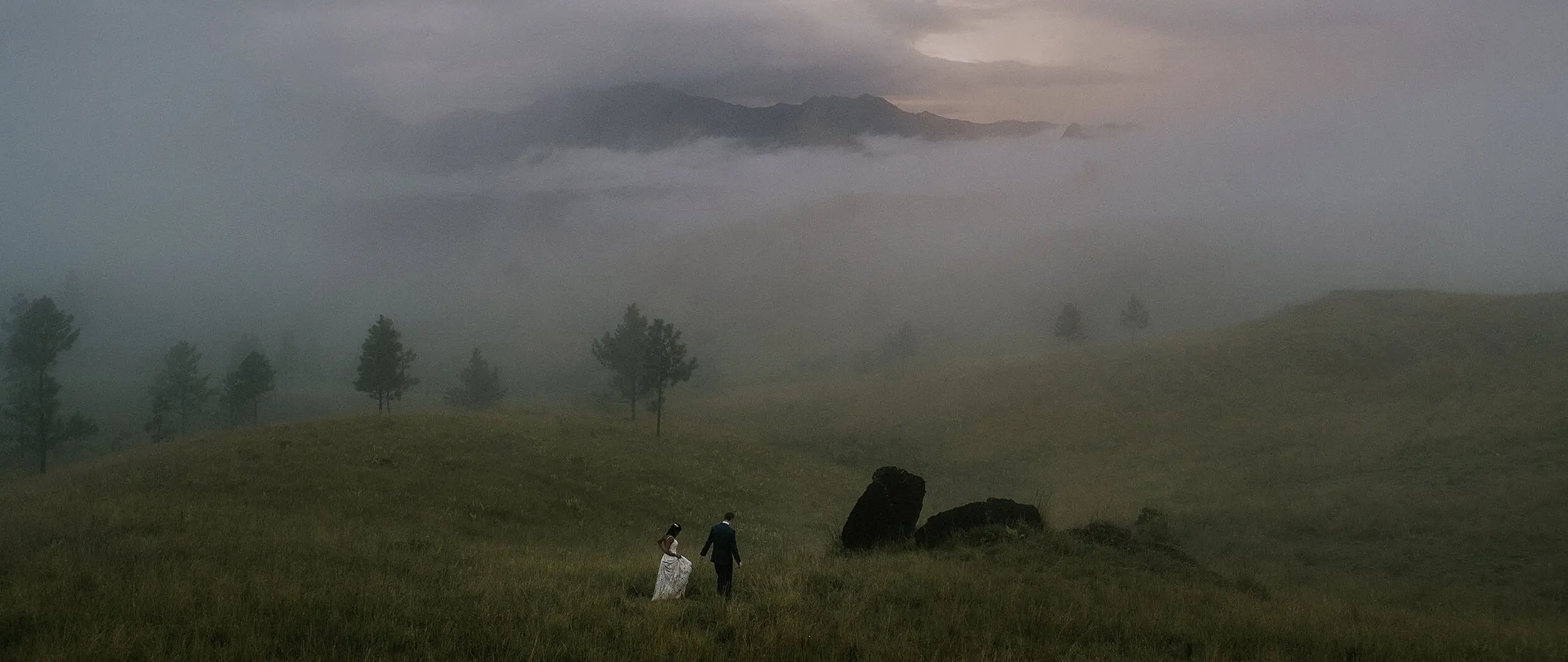 The couple far off on a misty hillside
