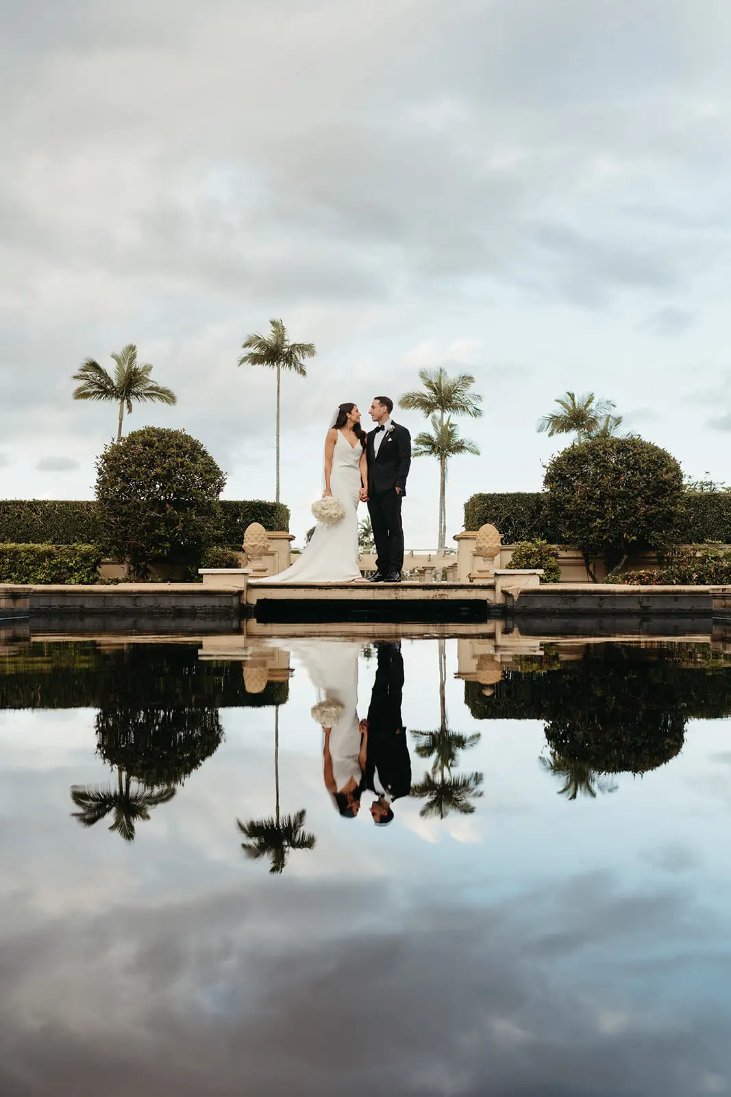 The couple small between the clipped hedges and their reflection, InterContinental Sanctuary Cove
