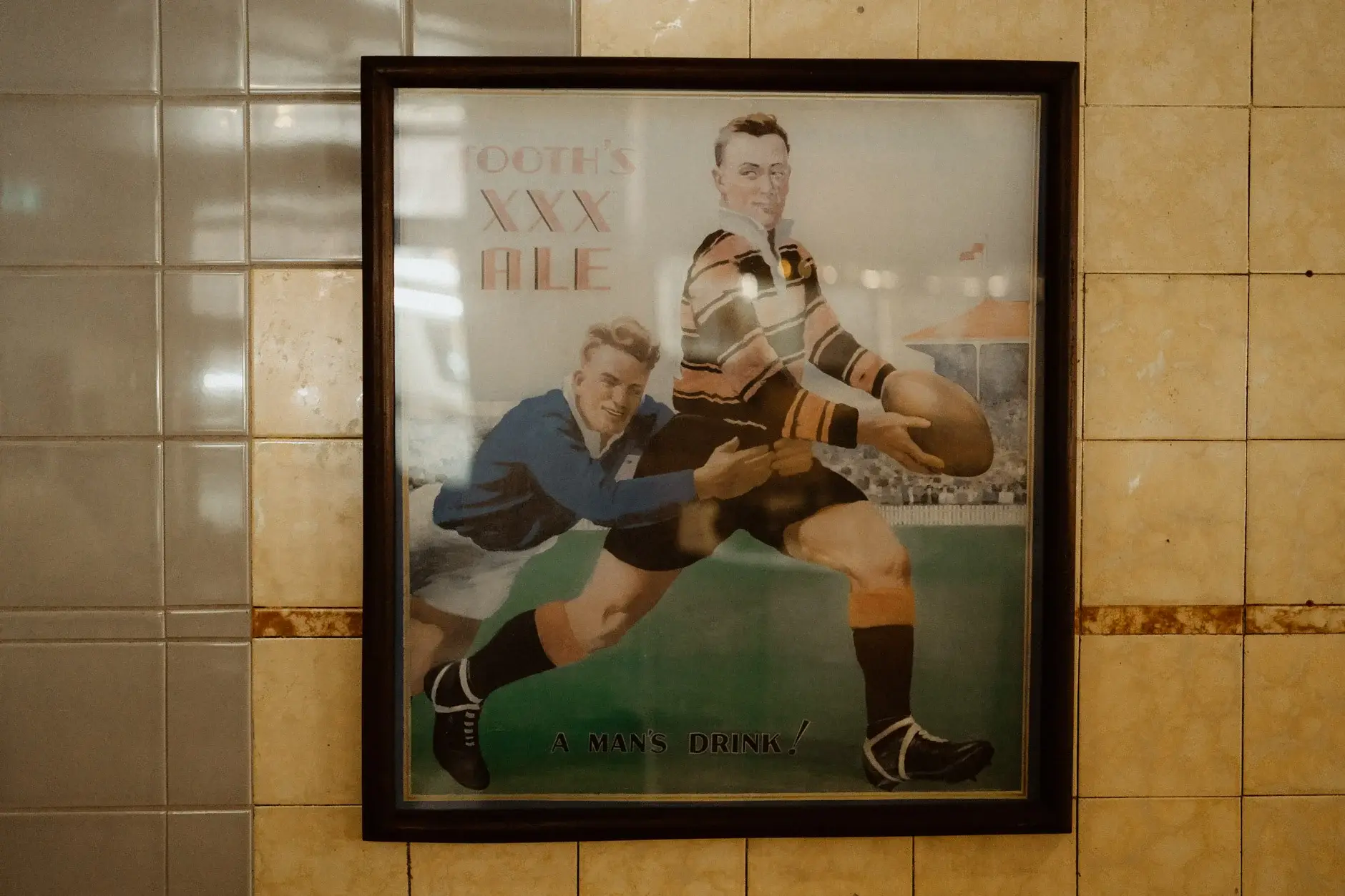 A vintage Tooth’s XXX Ale rugby poster on the tiled wall, The Old Clare Hotel