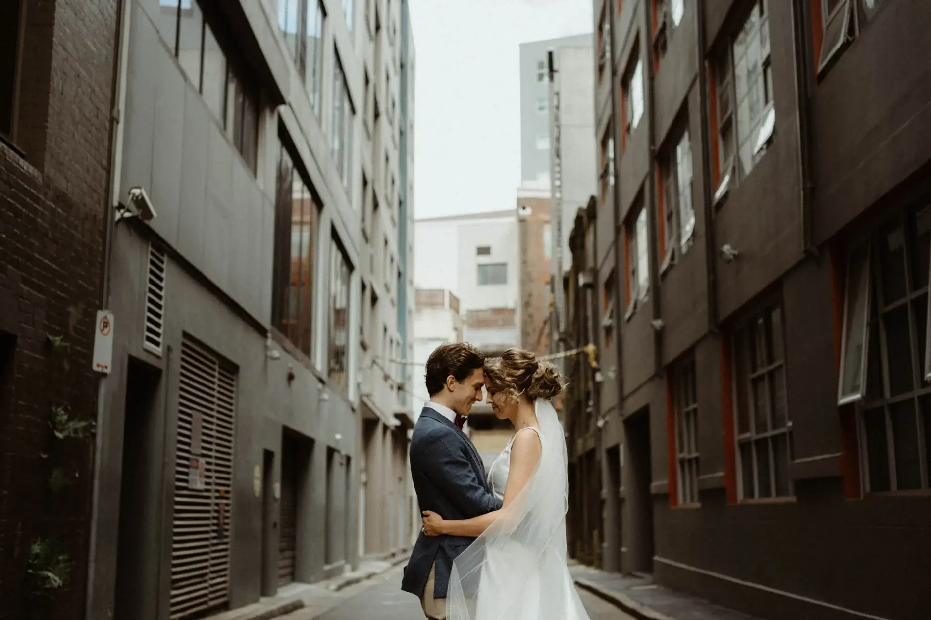 Kath and Ross embracing in the middle of the laneway, Chippendale