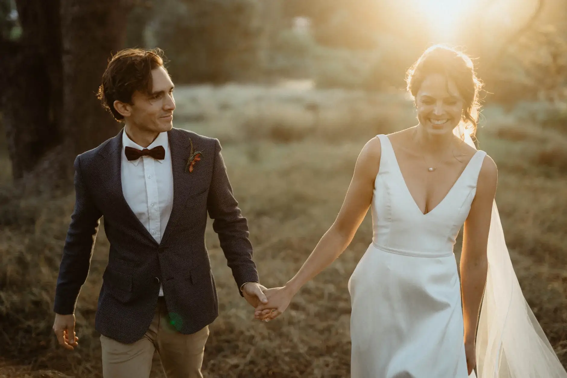 Kath and Ross walking hand in hand through dry grass, Centennial Park