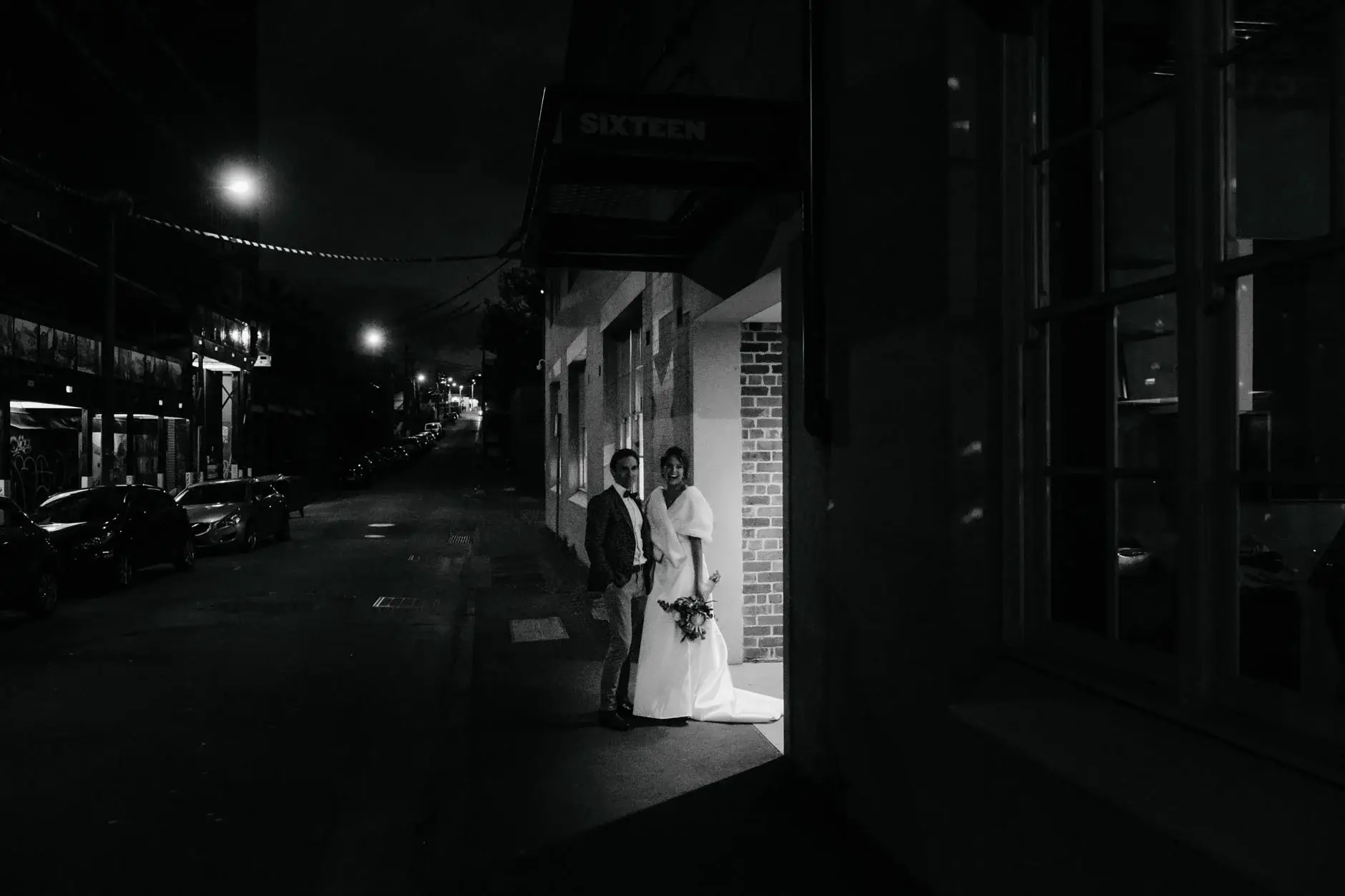 Kath and Ross on the Redfern street at night, black and white