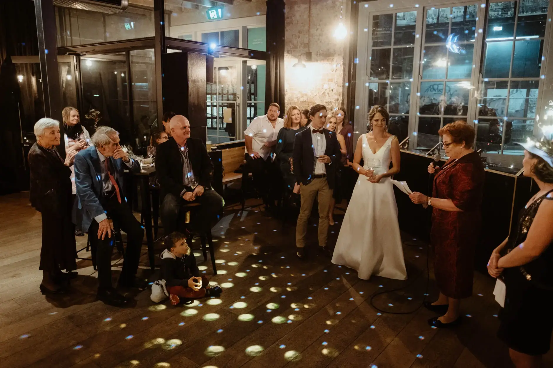 Kath greeting guests on the confetti-lit floor, Cake & Wine, Redfern