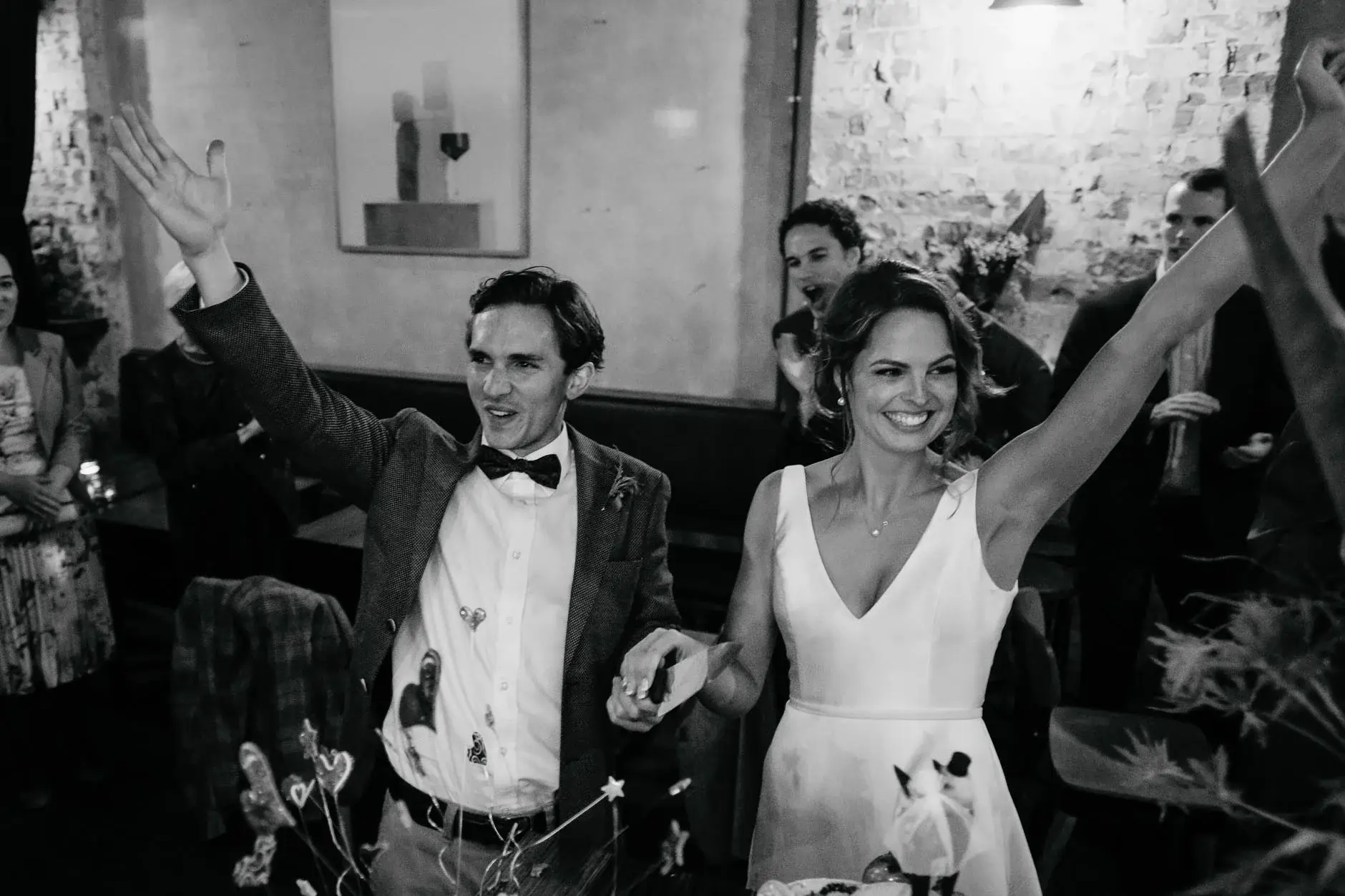 Kath and Ross with arms raised in celebration, black and white, Redfern