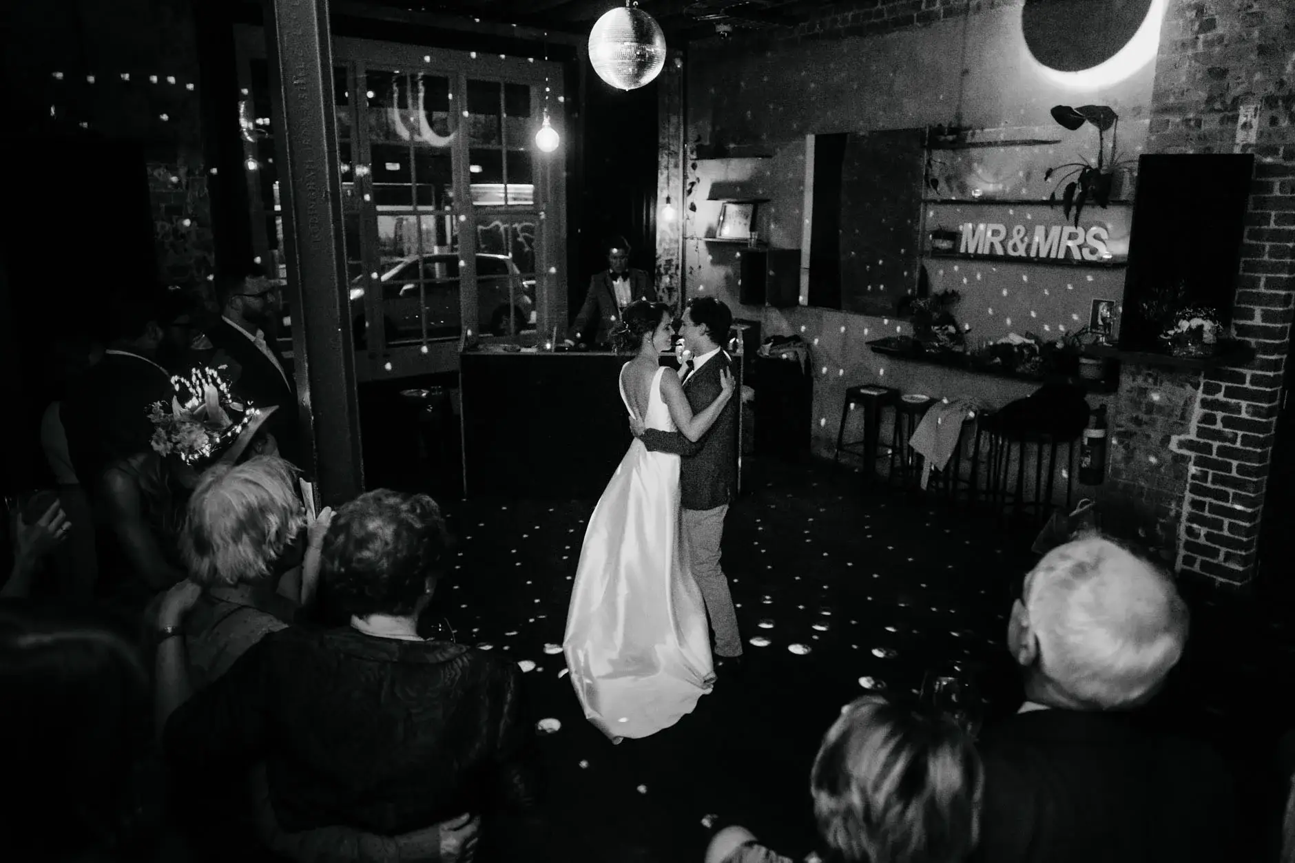 Kath and Ross dancing as guests watch, black and white, Redfern