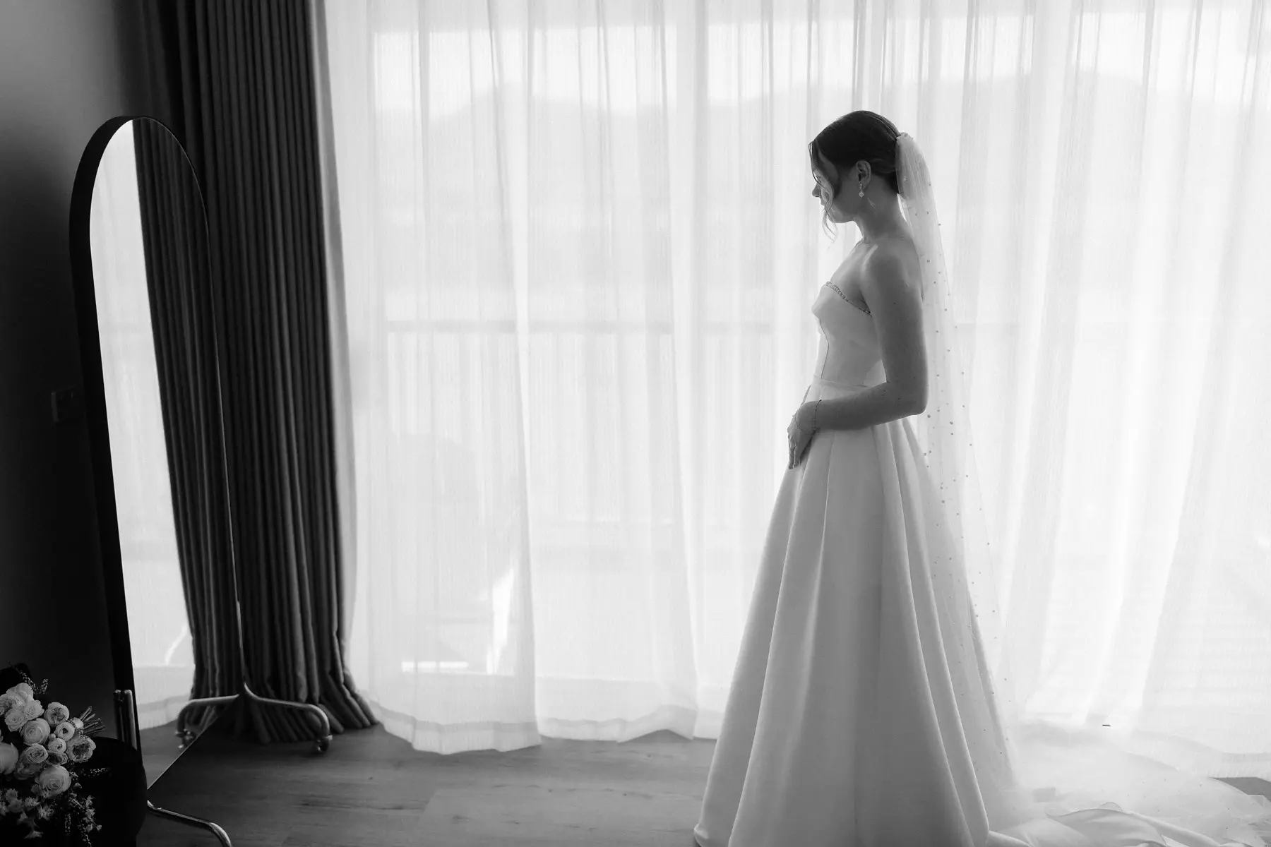 Nicole standing in her gown against the sheer curtains, in black and white, Kooroomba Vineyard and Lavender Farm