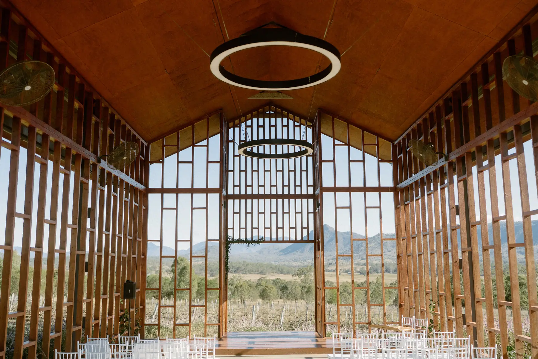 The open timber chapel set for the ceremony, ring light hanging from the ridge beam, Kooroomba