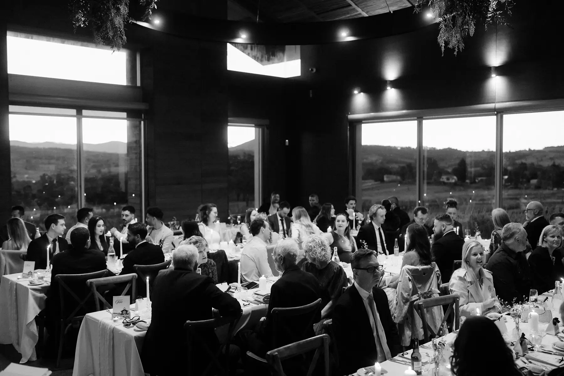 The reception room after dark in black and white, both long tables full, Kooroomba