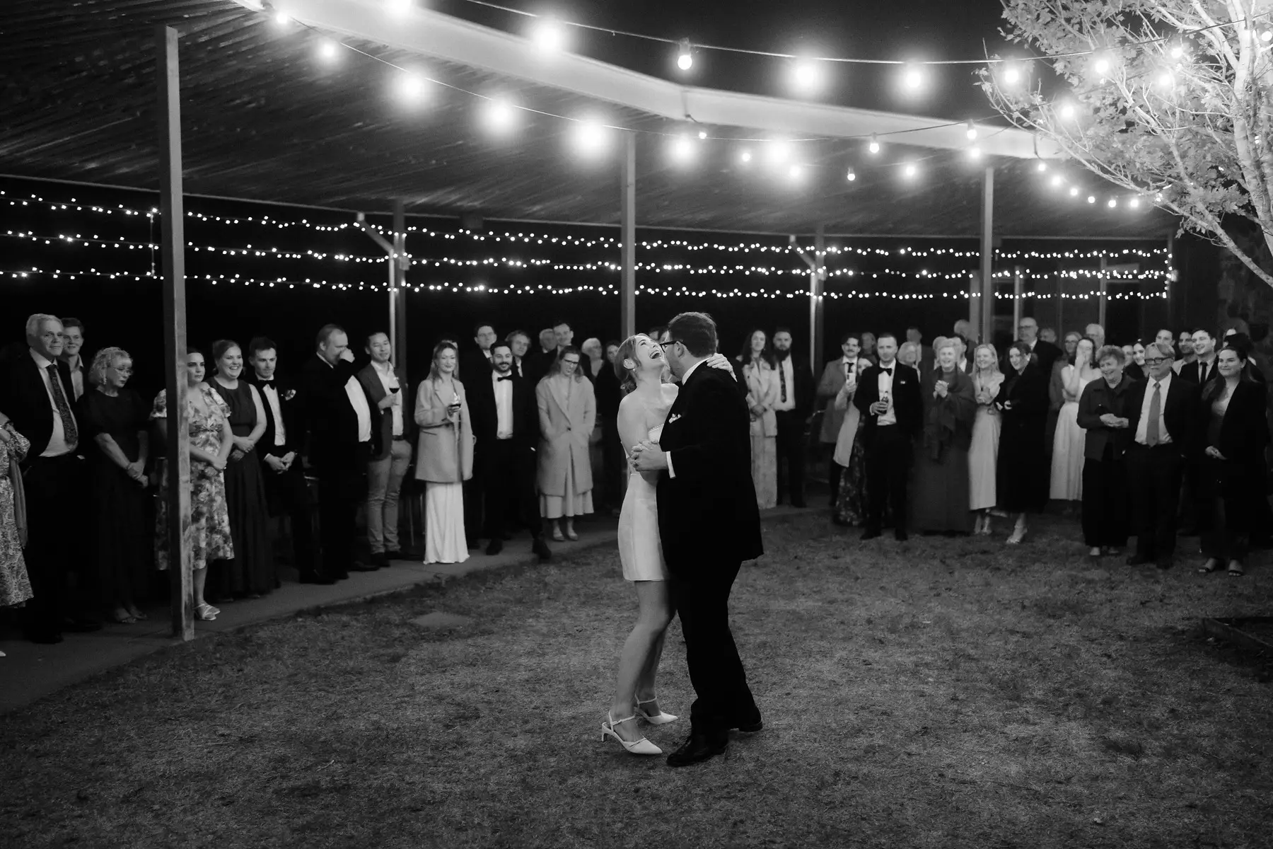 The first dance outside under the festoon lights, guests circled around, Kooroomba