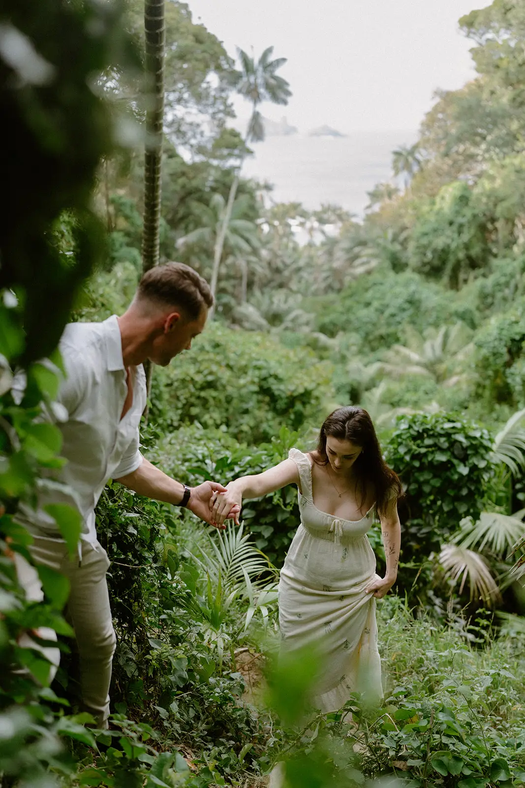 Brent reaching for Mel's hand among the palms, Lord Howe Island