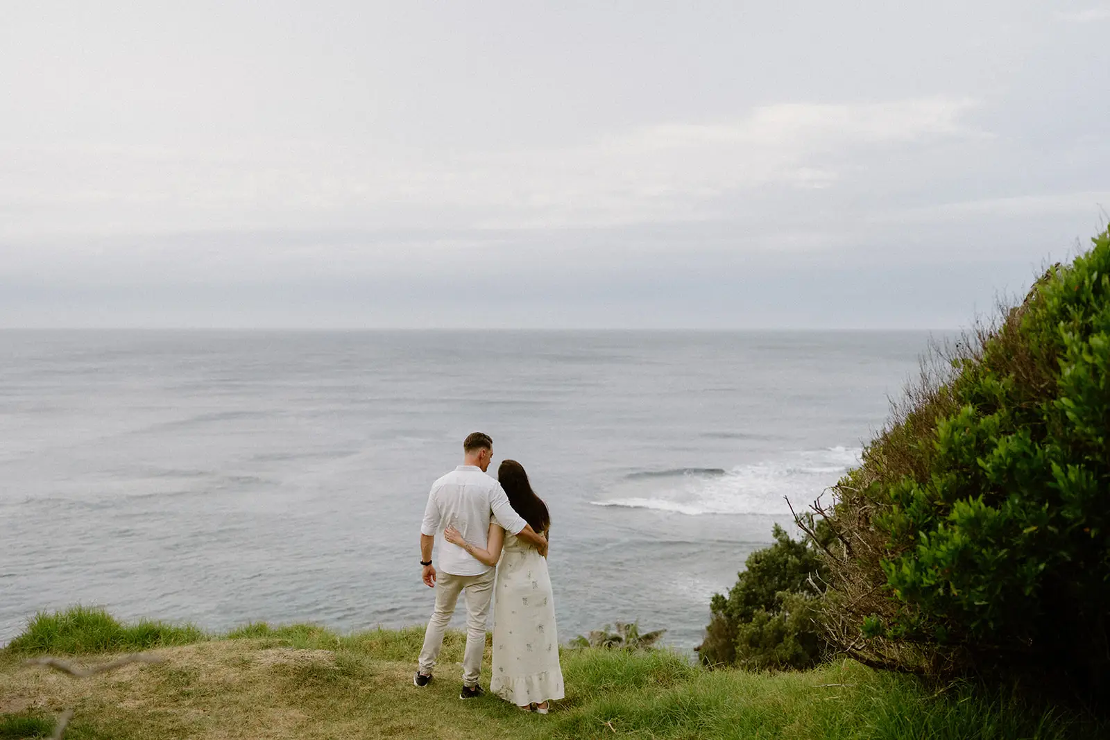 Mel and Brent on a grassy headland above the beach, Lord Howe Island