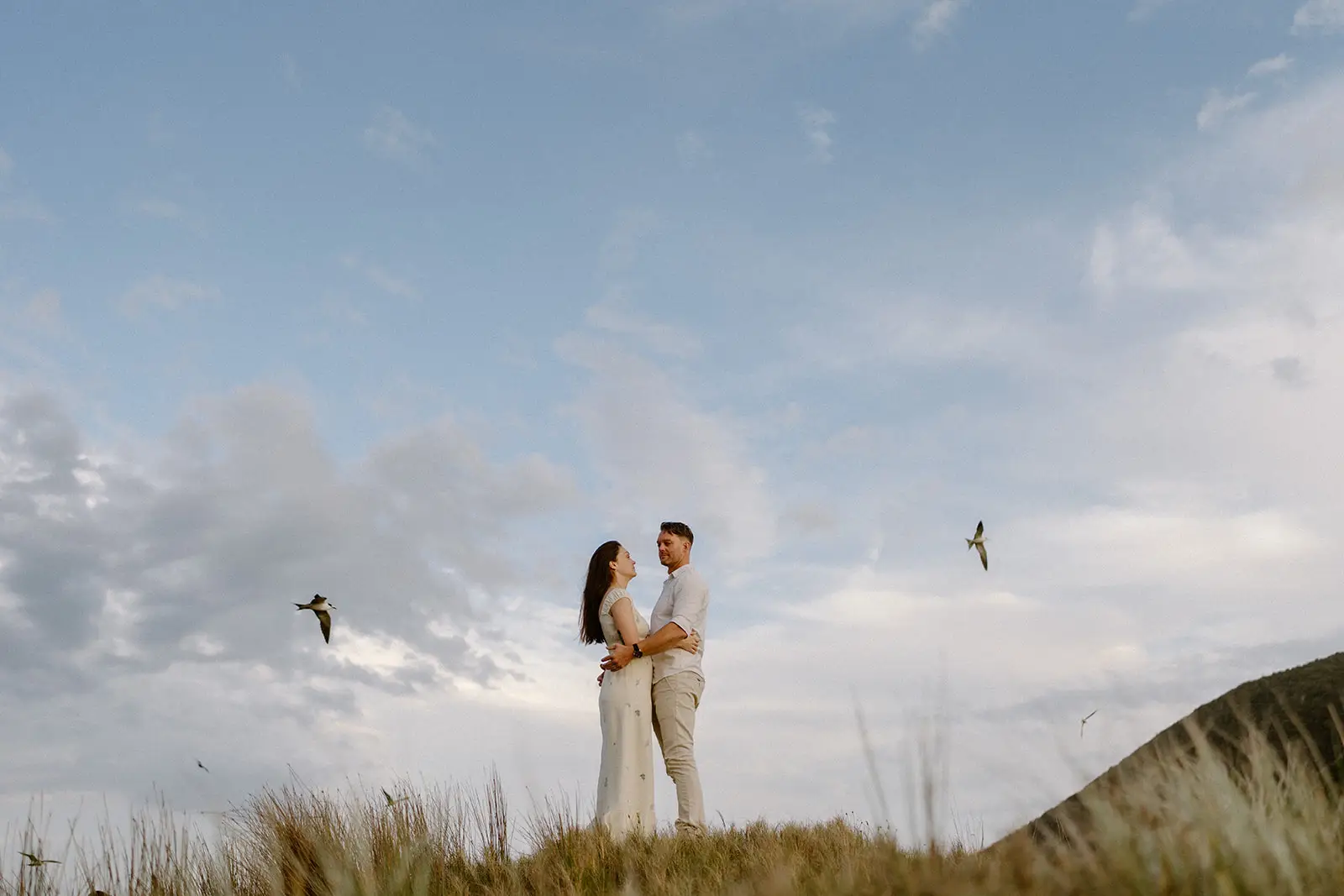 The couple embracing as birds wheel overhead, Lord Howe Island