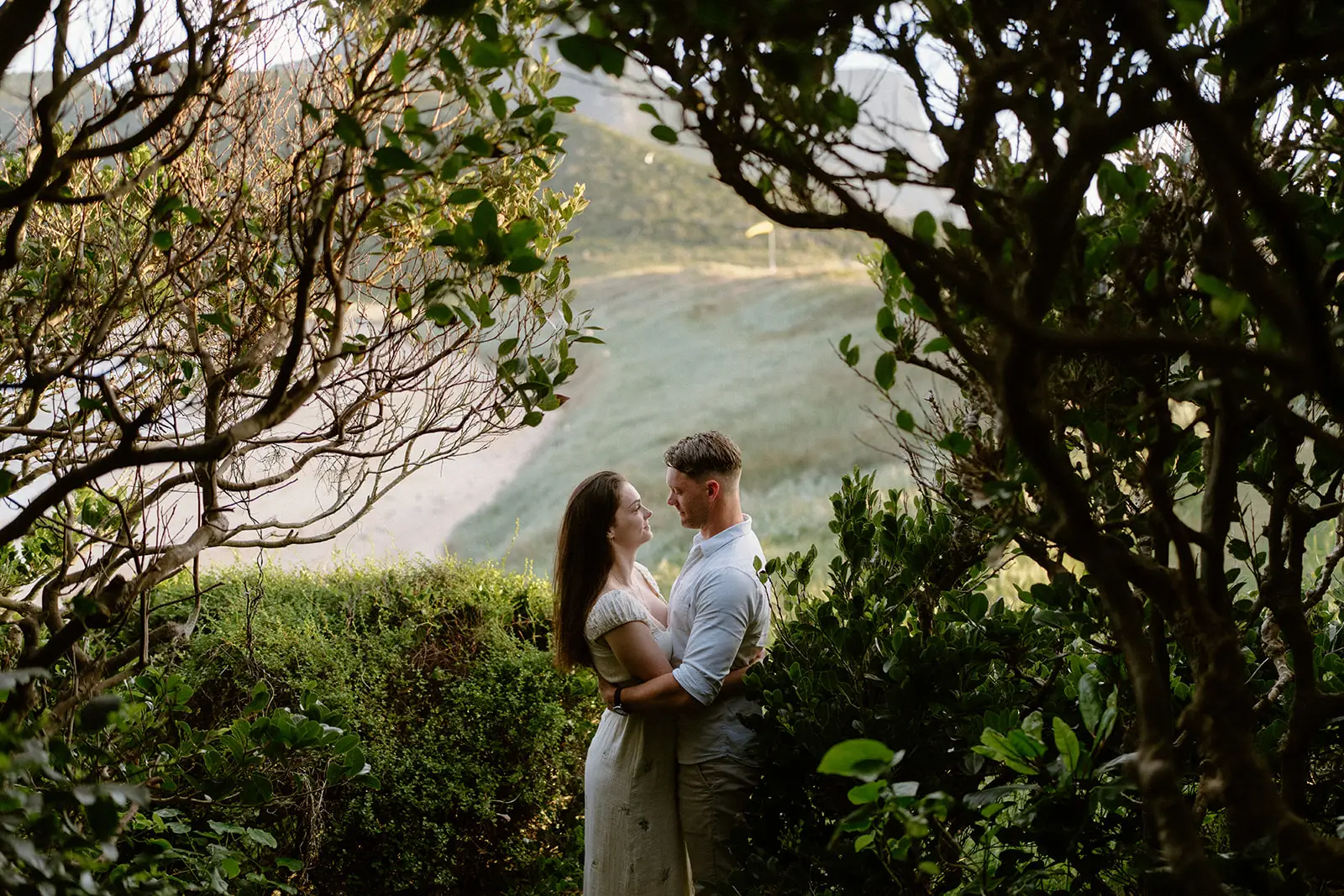 The couple framed by trees above a cove, Lord Howe Island