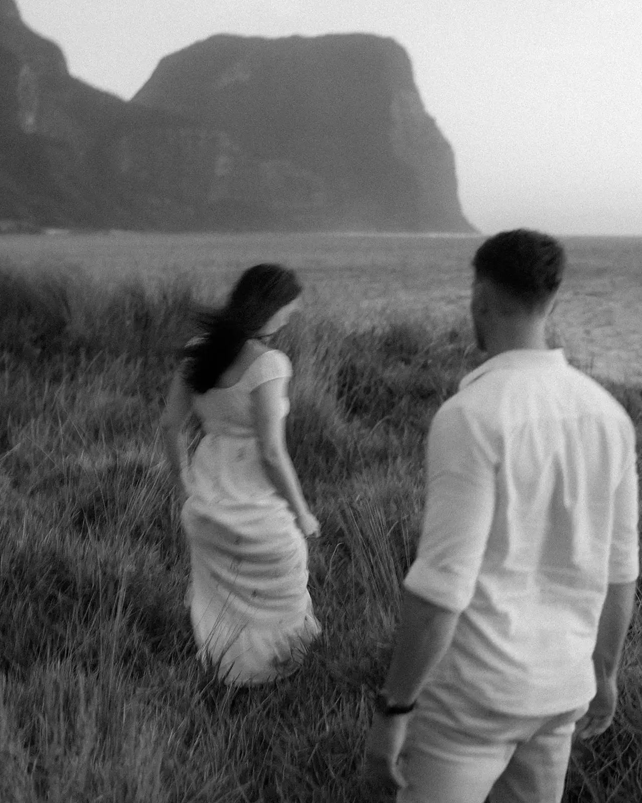 Mel and Brent in the grass beneath the mountains, Lord Howe Island