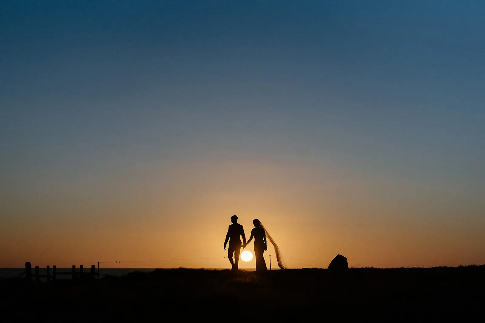 Mel and Brent silhouetted at sunset on the beach, Lord Howe Island