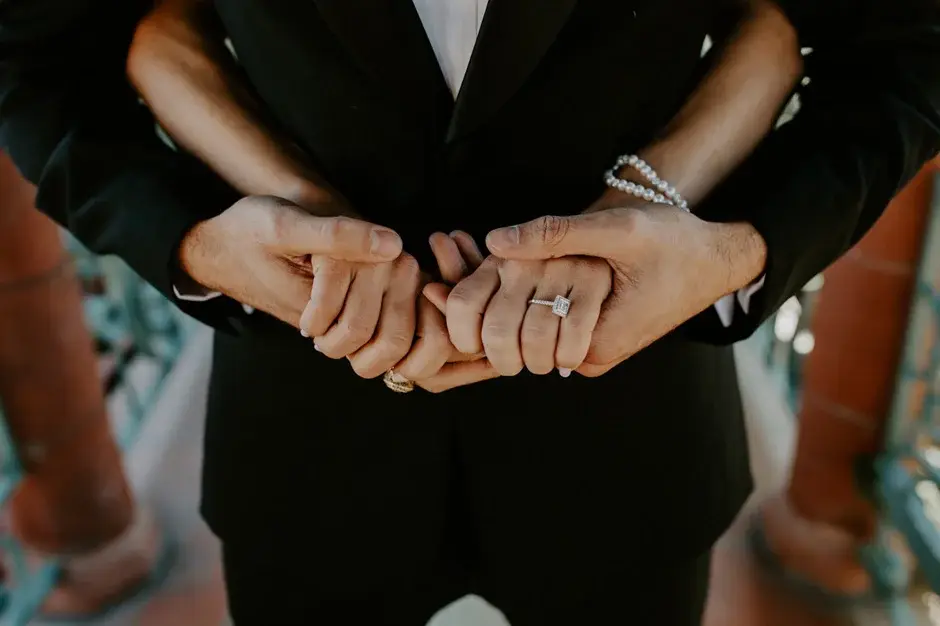 Aaron holding Amanda’s hands behind his back, ring showing