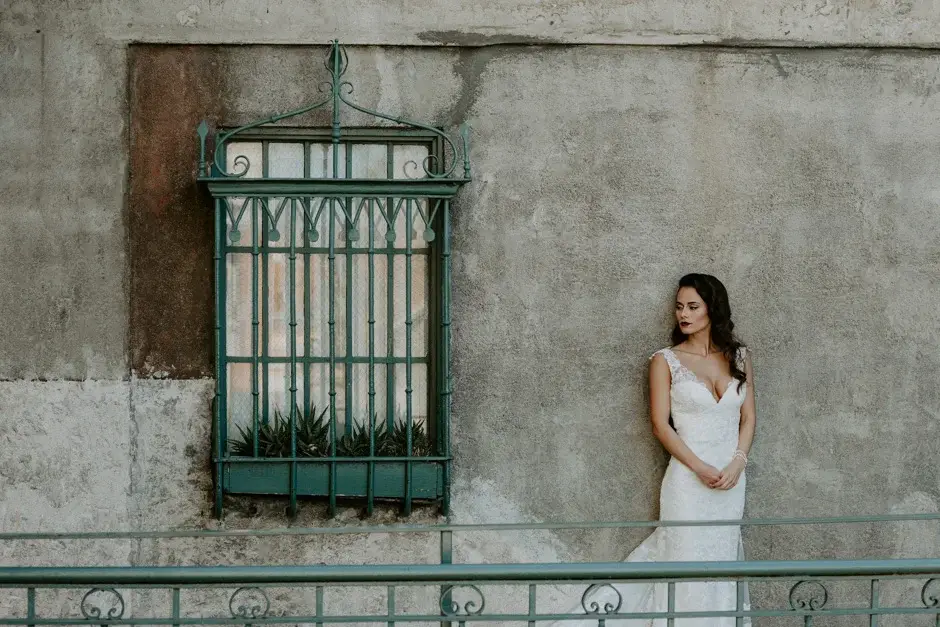 Amanda leaning by a green iron window grille, Riverside