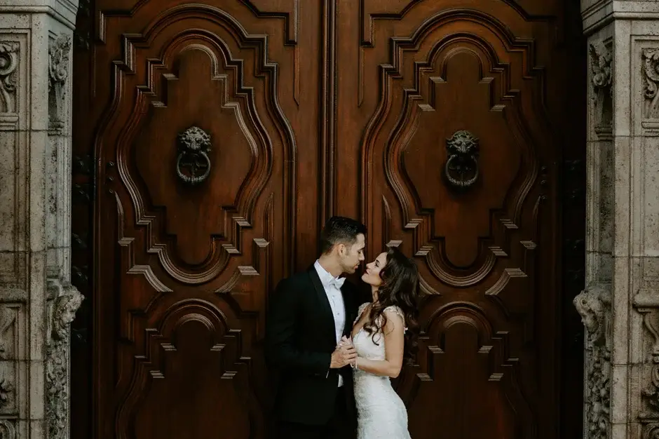 The two of them kissing before the great timber doors, Riverside