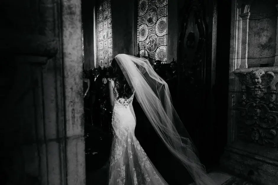 Amanda in the chapel doorway with her veil trailing, black and white
