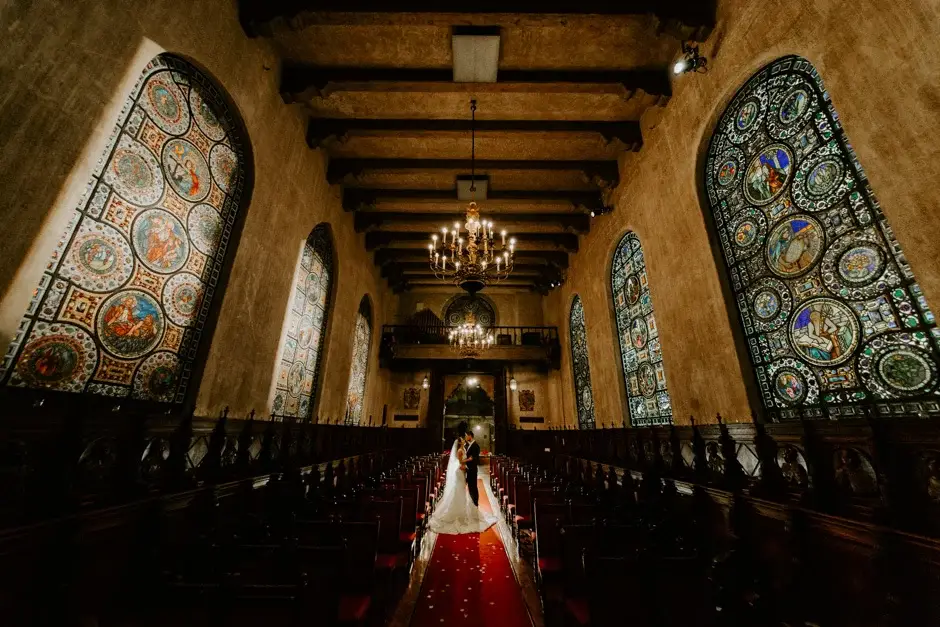 Amanda alone in the chapel between the stained glass windows