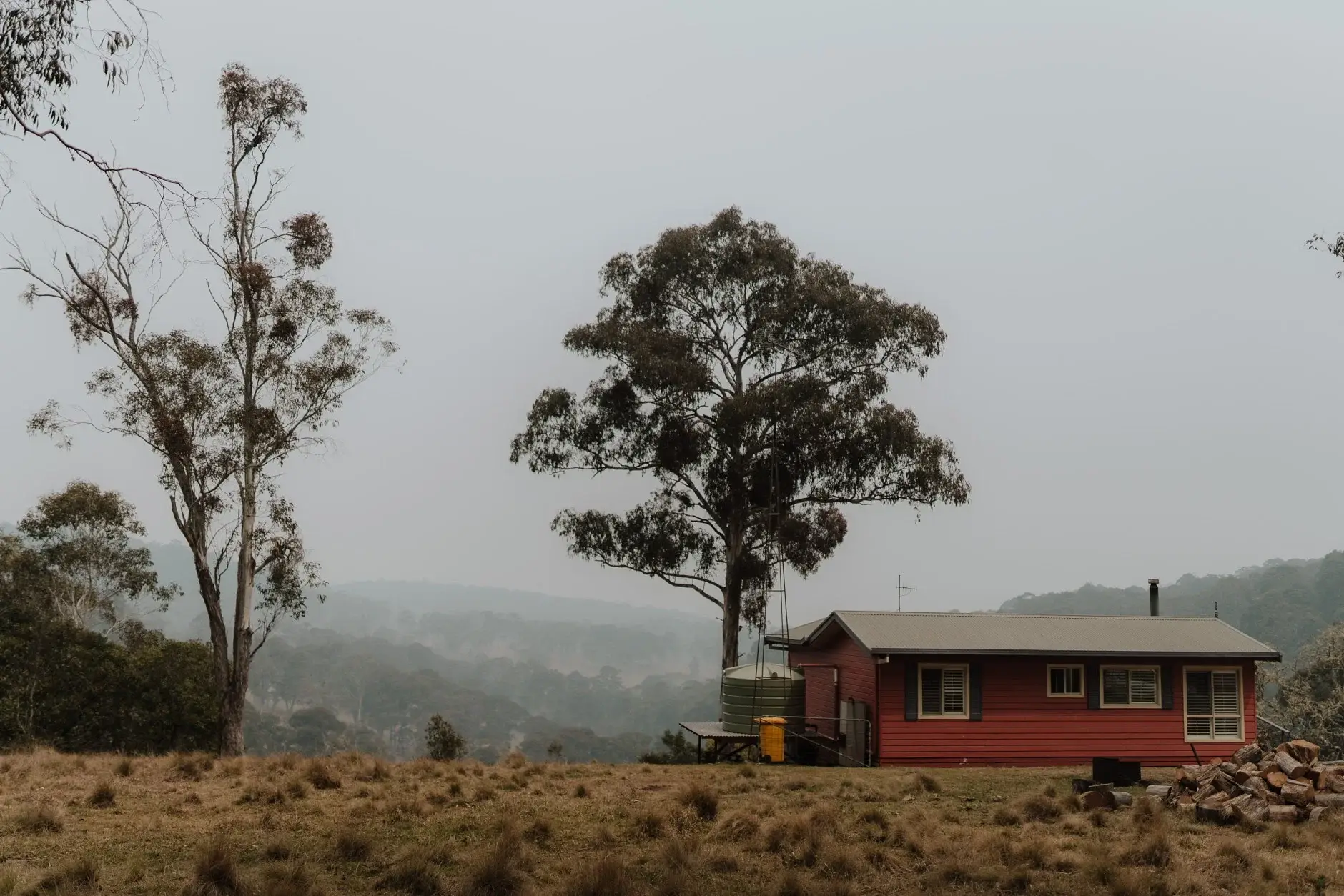 A small red cabin on the ridge in heavy smoke haze, New England