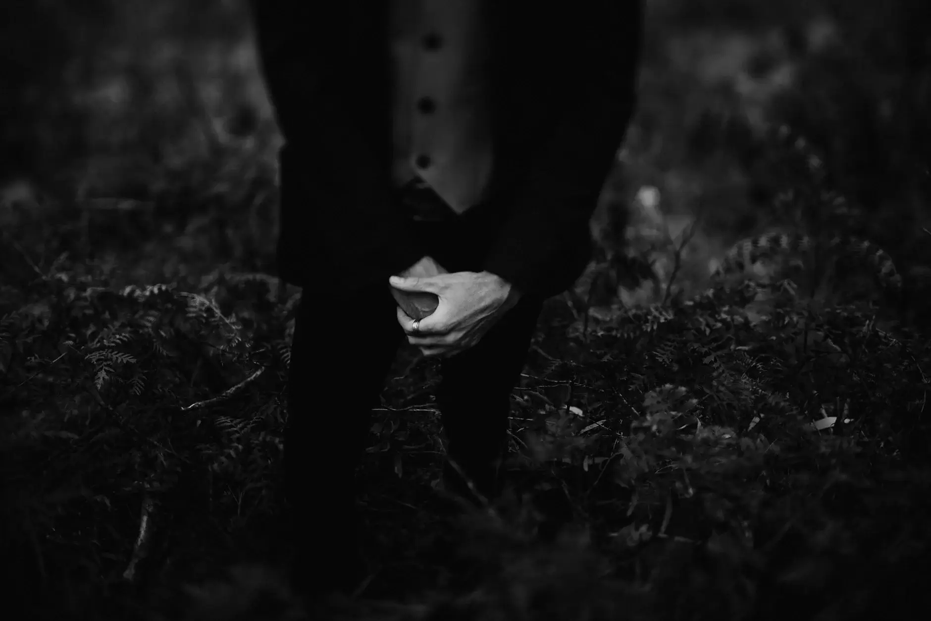 A handkerchief held low at his side, black and white, New England